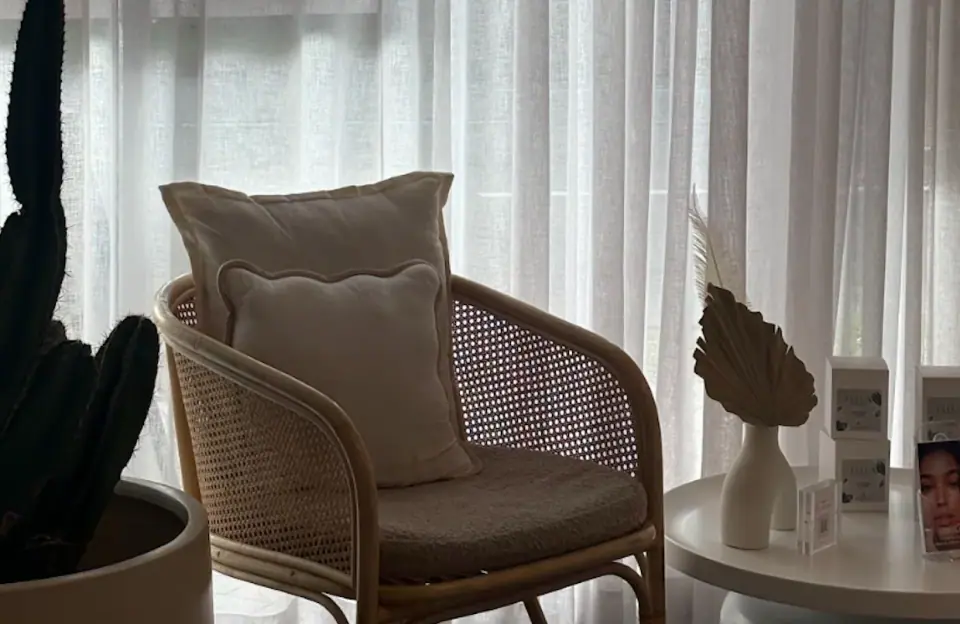 Rattan chairs beside a bright window in the Ellua salon