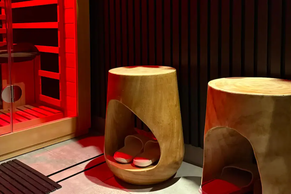 The infrared sauna room with warm timber and red light