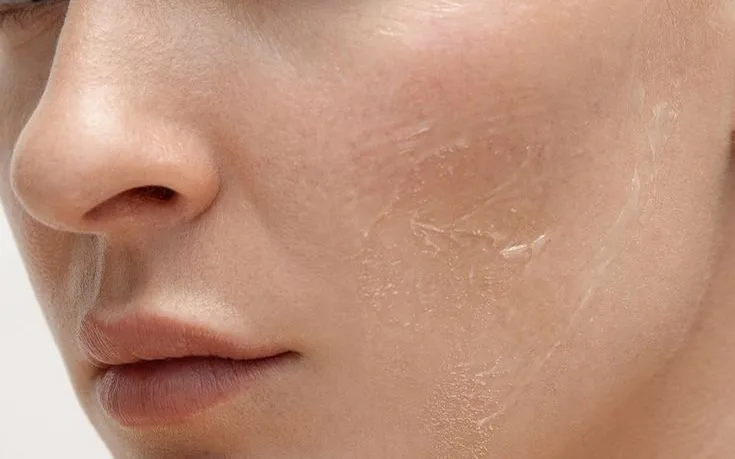 Close-up of a woman with smooth, even skin looking towards the camera